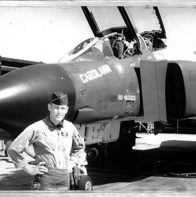 A black and white photo circa 1967 of Dale S Elliott standing in front of an F-15 fighter jet.