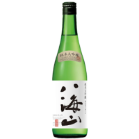 A green glass 720ml bottle of sake with the kanji HAKKAISAN written down the front of the white label in black ink.