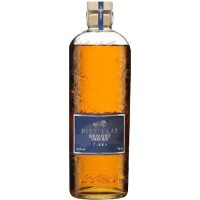 A bottle of rhum in a clear glass motled bottle made with recycled glass. The ocean-blue label has a silver wolf on it and the words Distillat Rhum.